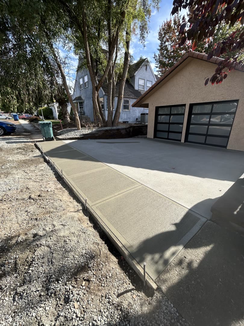 Freshly poured broom-finish driveway between two homes